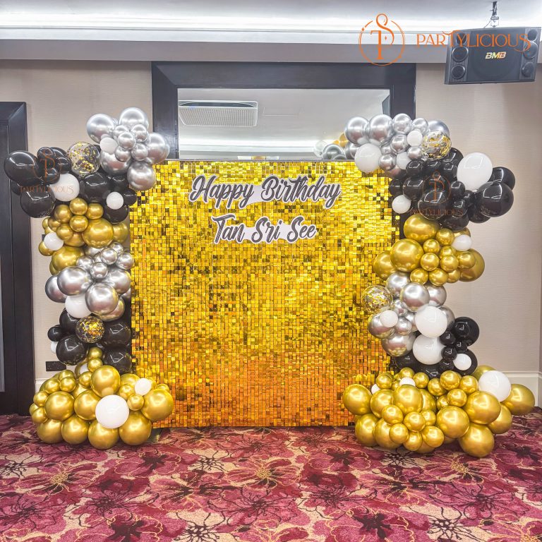 Sequin panel backdrop wall with balloon styling used as an event stage backdrop
